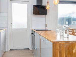Transにある6 person holiday home in Lemvigのキッチン(木製のカウンタートップ、ドア付)