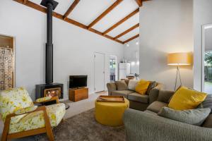 a living room with couches and a fireplace at West and Relaxation - Greytown Holiday Home in Greytown
