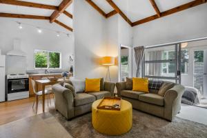 a living room with two couches and a table at West and Relaxation - Greytown Holiday Home in Greytown