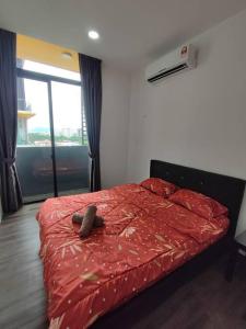 una camera con letto e piumone rosso di Kuching Luxurious Town Area Apartment a Kuching