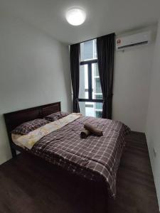 un letto con un cane che giace sopra di esso di Kuching Luxurious Town Area Apartment a Kuching