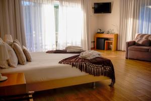 Cette chambre comprend un grand lit et une grande fenêtre. dans l'établissement Hotel Rural Quinta da Conchada, à Aguieira