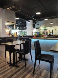 un ristorante con tavolo, sedie e bancone di Kuching Luxurious Town Area Apartment a Kuching