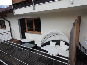 - Balcón con sofá y mesa en Ferienhaus Höllwarth, en Stumm