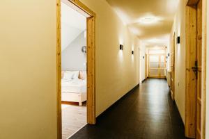 a hallway leading to a bedroom with a bed at Kakukk Vendéglő Panzió in Bánd