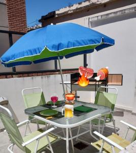 una mesa con una sombrilla azul en el patio en Habitat Plaza en Córdoba