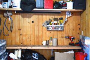 una pared de madera con un estante con herramientas. en Red Shutter Inn en Rossland