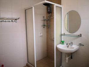 een badkamer met een douche, een wastafel en een spiegel bij Chris Cozyplace in Bayan Lepas