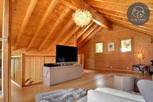 a living room with a flat screen tv in a cabin at Chalet Arwi in Ovronnaz