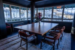einen Tisch und Stühle in einem Zimmer mit Fenstern in der Unterkunft The Mountains Hotel in Sierra Nevada