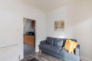 a living room with a blue couch and a kitchen at Charming Terraced House in Central Hoylake in Hoylake