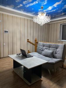 a laptop on a table in a room with a couch at Hostel 4U in Bishkek