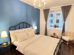 a bedroom with a large bed and a chandelier at Erkel Luxury Home in Budapest