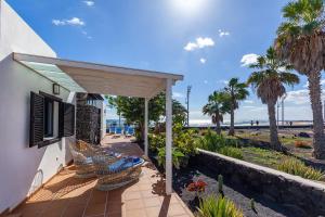 卡門港的住宿－Casa La Malondra，一个带棕榈树和海滩门廊的房子