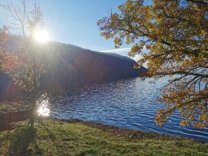 a view of a lake with the sun shining at Gîte de campagne Gaspard 