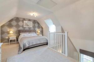 a bedroom with a large bed and a staircase at Detached family house with private garden. in Arlesey +8 photos