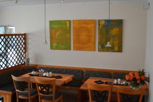 a dining room with tables and chairs and paintings on the wall at Aparthotel Sprendlingen in Sprendlingen