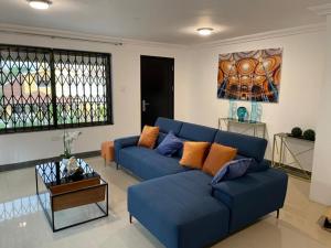ein Wohnzimmer mit einem blauen Sofa und einem Tisch in der Unterkunft Nuben Court-Accra in Accra