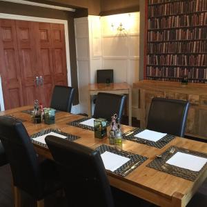 a large wooden table with chairs around it with a tableablish at Swn Y Mor in Llandudno