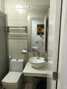 a bathroom with a sink and a toilet and a mirror at Birch tower by matthqueenroom, malate in Manila