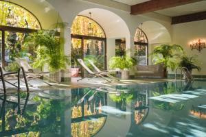 basen w domu z krzesłami i oknami w obiekcie Hotel Gasthof Brandstätter w mieście Salzburg