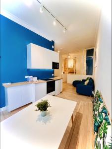 a kitchen with a white table and a blue wall at Suite Bayle - Standing - Hyper centre in Montpellier