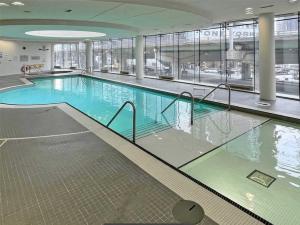 a large swimming pool in a building at Luxury Condo in the Heart of Toronto - Next to Scotiabank Arena in Toronto