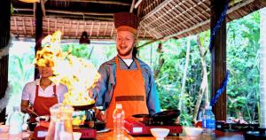 a man is cooking in a kitchen with a woman at Mad Monkey Hoi An in Hoi An +125 photos