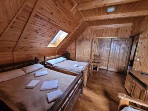 a bedroom with two beds in a wooden cabin at Ворота Карпат in Dilyatyn