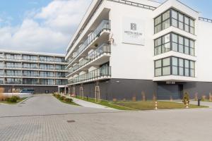 a large white building with a parking lot at Westin House Resort Apartment Kołobrzeg by Noclegi Renters in Kołobrzeg