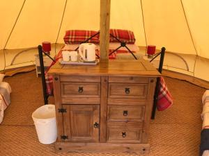 a wooden dresser with two toilets on it in a tent at Cox Hill Glamping Benson in Truro