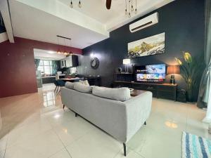 a living room with a couch and a tv at Langkawi Cozy Holiday Home at Desa Impian by Zervin in Kuah