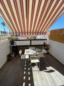 a patio with a table and chairs on a roof at Apartment Soleil Altamar in Playa de las Americas