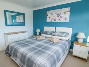 - une chambre dotée d'un lit avec un mur bleu dans l'établissement Blackwater Meadows, à Ellesmere
