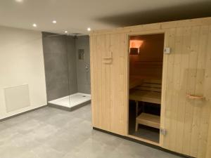 La salle de bains est pourvue d'une armoire en bois et d'une douche. dans l'établissement Ferienwohnung Schleifnest, à Heppenheim