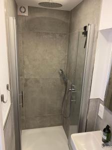 a shower with a glass door next to a sink at Ferienwohnung Schleifnest in Heppenheim an der Bergstrasse