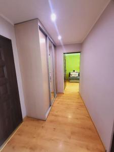 um quarto vazio com um corredor com uma porta e piso de madeira em 2 Rooms Apartment - OLD Town em Breslávia
