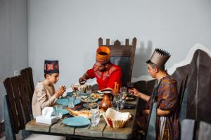 a group of three people sitting at a table eating food at The Forgotten Kingdom in Lchashen