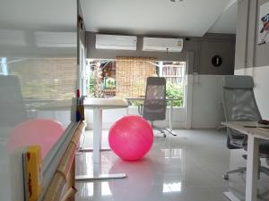 a room with a table and a pink ball on the floor at COWORX Koh Lanta in Ban Mo Nae
