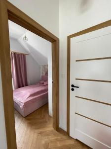Una puerta que conduce a un dormitorio con cama en Apartament Jastrzębia Góra 12 B en Władysławowo