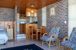 a room with a bed and a table and chairs at Kormorant in Gansbaai