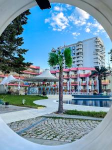 Flamingo Beach Hotel في ساني بيتش: اطلالة على منتجع فيه نخلة ومسبح