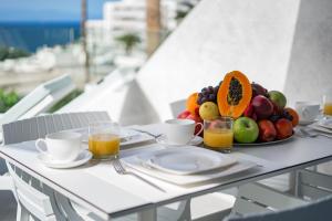 アデへにあるOcean View Luxury Apartment PH014のフルーツプレートとオレンジジュースを盛り付けたテーブル