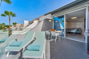 un balcon avec des chaises bleues et une table sur un immeuble dans l'établissement Ocean View Luxury Apartment PH014, à Adeje