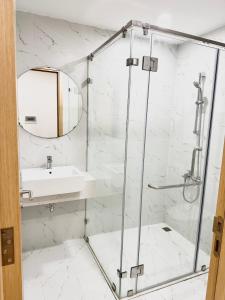 ein Bad mit einer Dusche und einem Waschbecken in der Unterkunft Căn hộ du lịch TMS 5 sao in Quy Nhon