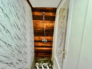 a bathroom with wooden walls and a hallway with a door at Diamond Glamping by BIO Management in Tabanan