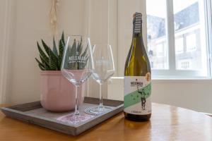 - une bouteille de vin et 2 verres à vin sur une table dans l'établissement De Dekenije, à Zutphen