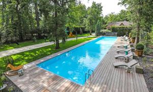 een afbeelding van een zwembad met ligstoelen op een houten terras bij The Iflissen Nest - Luxury Appartment in Lamorlaye