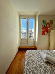 a bedroom with a bed and a large window at Atuaire Home Preciosa vivienda Vistas a la Catedral Parking Incluido in Burgos