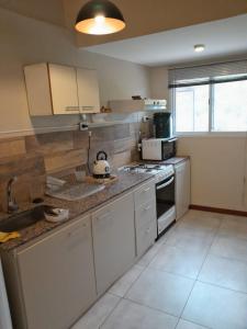 a kitchen with a sink and a stove top oven at AMORADA in Potrerillos +5 photos